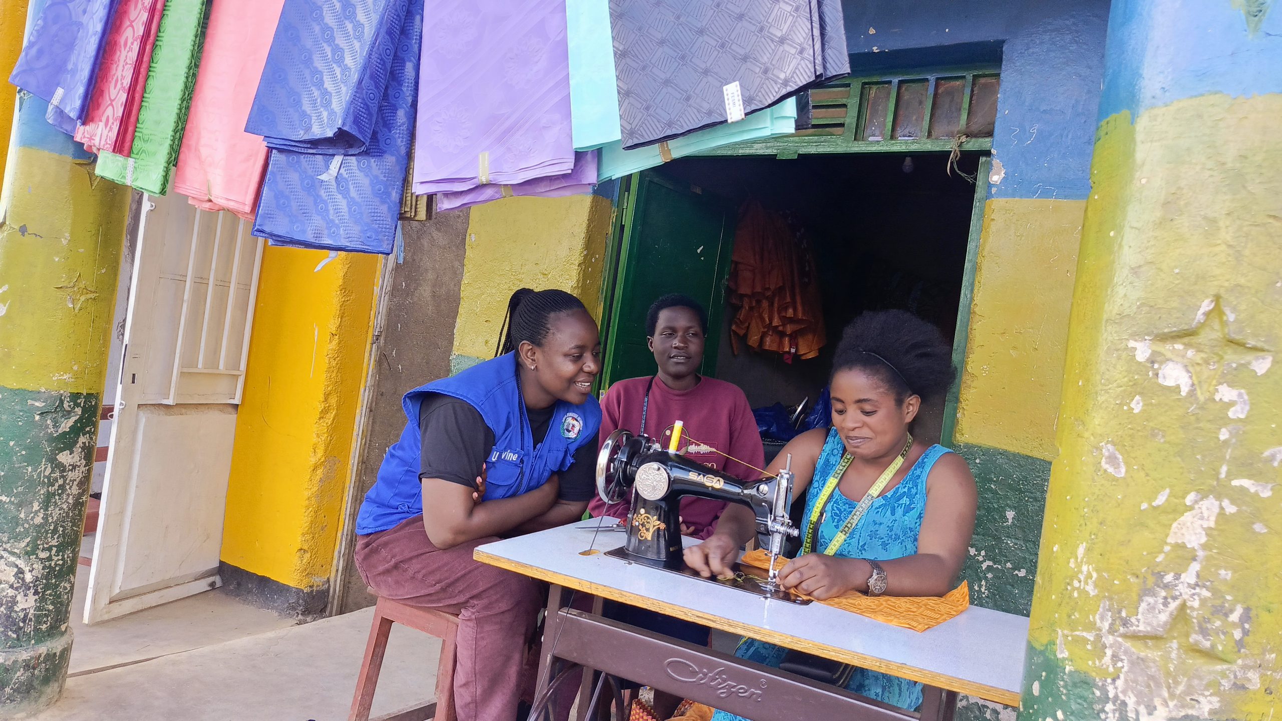 A young woman working at a sewing machine in her tailoring workshop supported by Vision Jeunesse Nouvelle