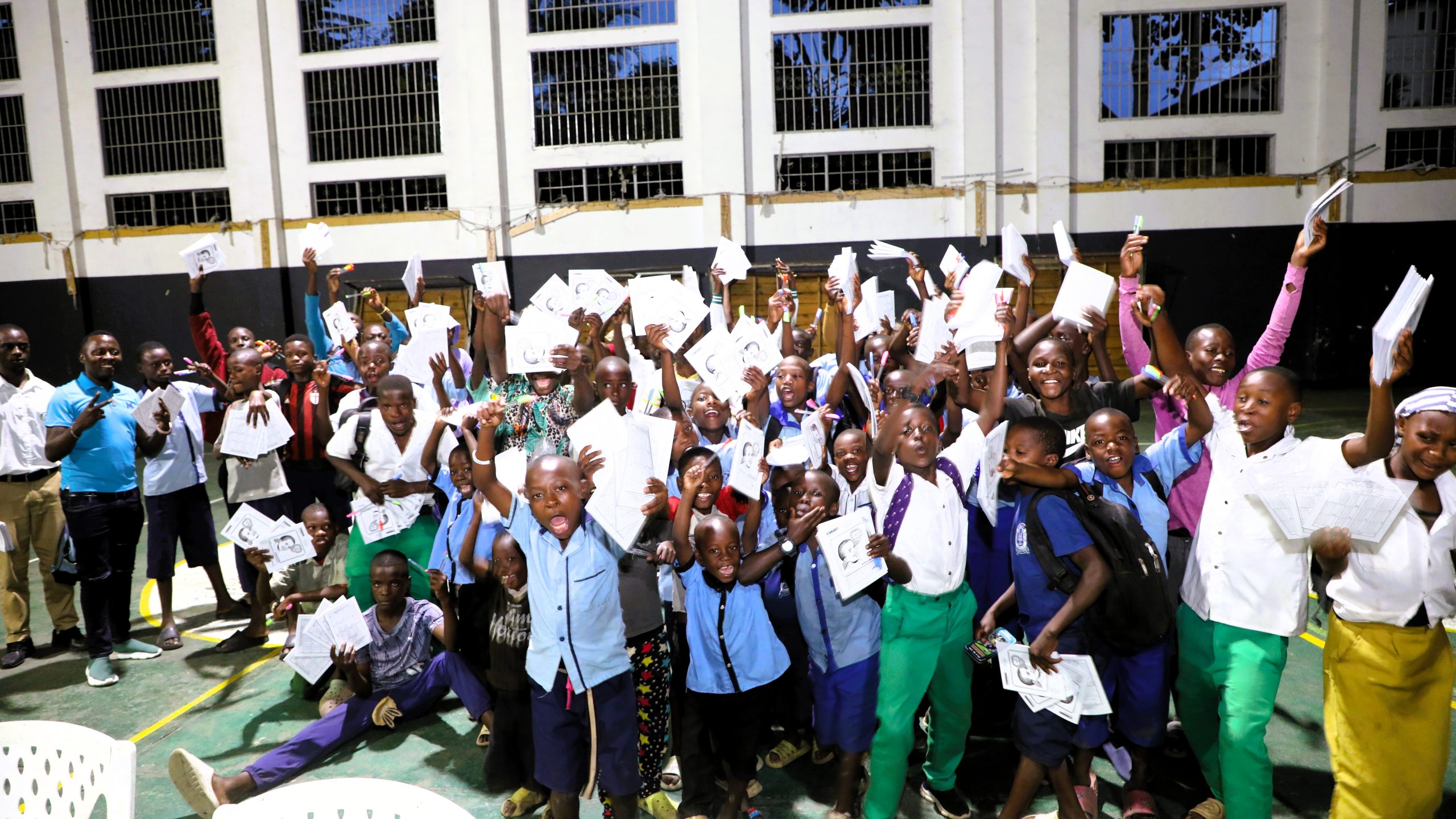 Young people at a Vision Jeunesse Nouvelle gathering cheering with their hands raised
